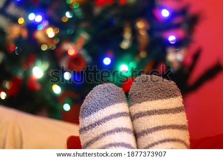 Feet in fluffy socks resting on the sofa. Selective focus.