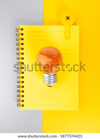 orange lamp and book clips on trendy ultimate grey and illuminating background. Creative idea concept. Minimalism. Top view. Flat lay. Colors of 2021