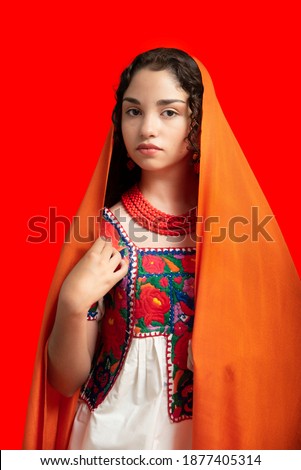 latin adolescent woman with traditional folk costume with multicolored background, dancer and mexican model posing traditional mexican clothing