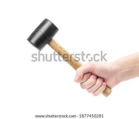 The hand holds a rubber mallet with a wooden handle. Сlose up. Isolated on a white background. Royalty-Free Stock Photo #1877450281