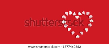 sweets-pink and white marshmallows in the shape of hearts on a red background congratulate you on Valentine's Day. copy space, banner