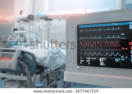 Heart monitor with ECG lines on the background of critical patient in the intensive care unit. Royalty-Free Stock Photo #1877467219