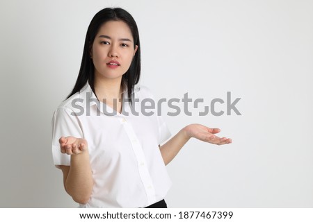 The Asian girl in university uniform standing on the white background.