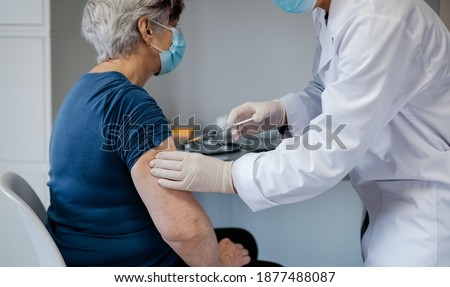 Senior woman being vaccinated against coronavirus by a female doctor Royalty-Free Stock Photo #1877488087
