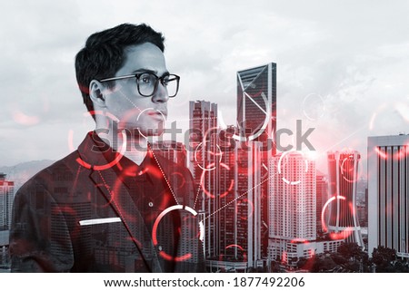 Eastern young businessman pondering on technology at business process to achieve tremendous growth. Worldwide process to conduct transactions. Tech hologram icons over Kuala Lumpur background