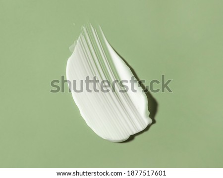 Face or body white cream hair balm green sage background Royalty-Free Stock Photo #1877517601