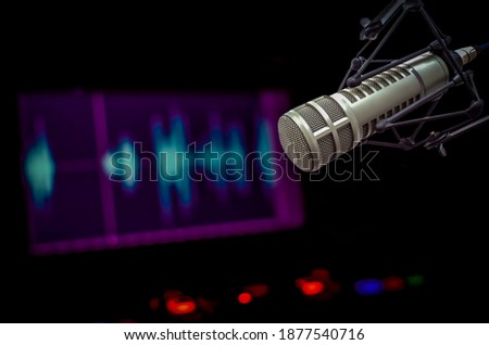 Professional microphone and sound wave on the screen