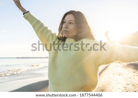 A selective focus shot of an attractive female posing on a beach on a sunny day in Benicssim, Spain