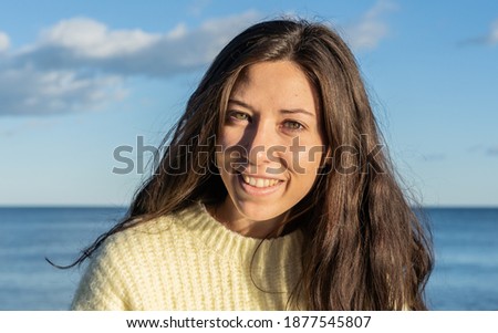 A selective focus shot of an attractive female on a beach in Benicassim, Spain looking at a camera