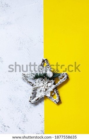 Winter holiday background with a star. Illuminating Yellow and Ultimate Gray Color of the year 2021. Copy space.Top view flat lay.