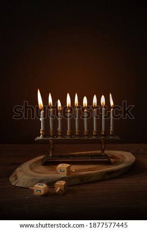 Image of Jewish holiday Hanukkah with menorah (traditional Candelabra) and wooden dreidels (spinning top) on vintage wooden Board 