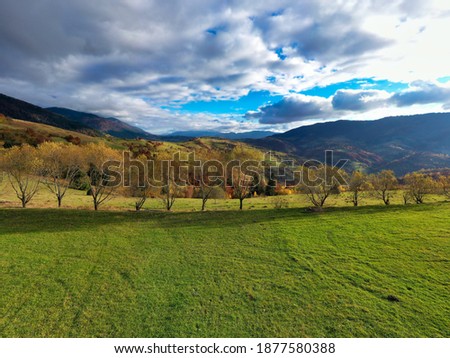 Sky with white and fluffy layer of clouds over green autumn hills, Aerial panoramic drone shot