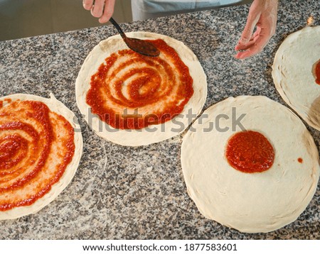 man's hands process of making pizza