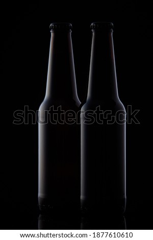 Two black bottles on black background
