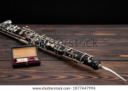 musical instrument, on the table lies an English horn with a reed  Royalty-Free Stock Photo #1877647996
