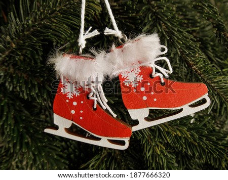 New Year's and New Year's toys hang on the tree. red wooden skates with fur on a branch. Christmas and New Years concept.High quality photo