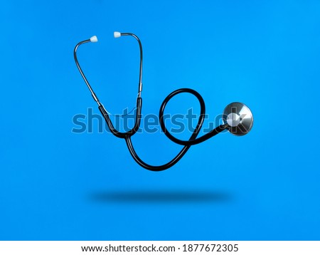 Levitating stethoscope on blue background and shadow under it. Stock photo. Royalty-Free Stock Photo #1877672305