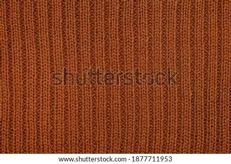 Wool knitting fabric from light brown, handmaid, needlwork, ribs. Clousup. Horizontal photography