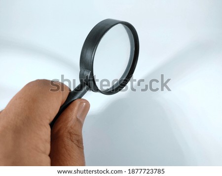 Selective focus.Hand holding magnifying glass with copy space and white background.