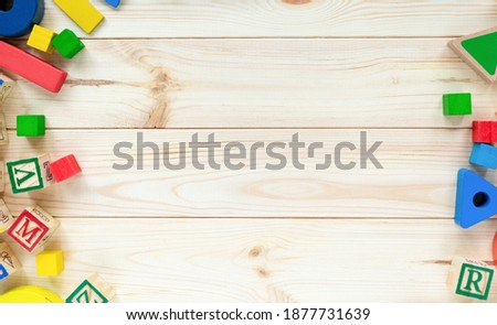 Educational toys blocks, numbers, letters on the wooden table. Toys for kindergarten, preschool, or daycare. Copy space for text. Top view Royalty-Free Stock Photo #1877731639