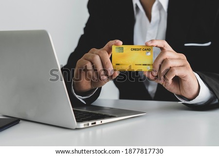 ิbusiness hand hold credit card and use laptop for shopping and check discount sale from home