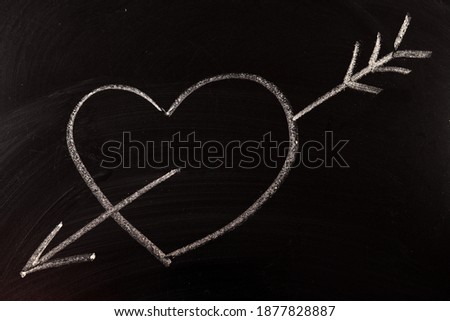 Heart with an arrow drawn on a chalkboard, a symbol of love