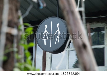 Artistic toilet sign, clearly visible with portraits of men and women, looks attractive and easy to understand, in a restaurant in Thailand.