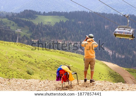 Man make a photo of chairlift in a mountain region in summer