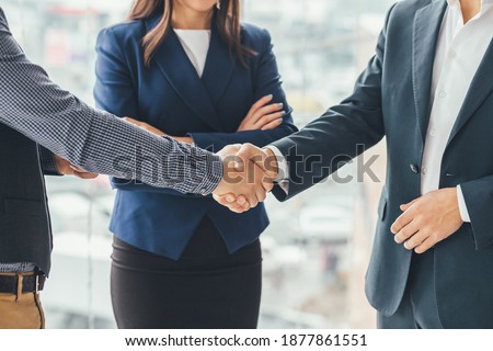 Cropped picture of delighted business people shaking hands making a profitable deal.