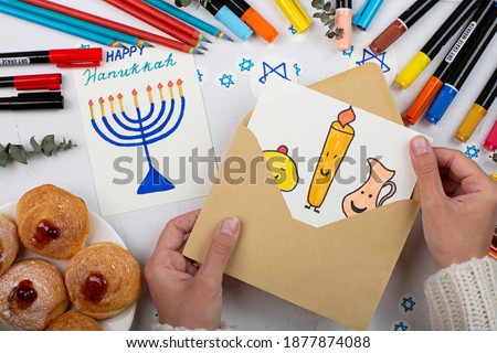 Jewish holiday Hanukkah greeting cards on gray concrete background. Hanukkah food doughnuts. Top view, flat lay, mockup