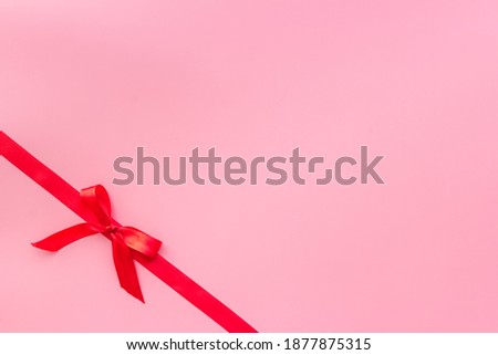 Red ribbon with bow for holiday gift box. Top view, copy space