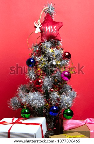 Christmas tree with gifts on red and white background.
