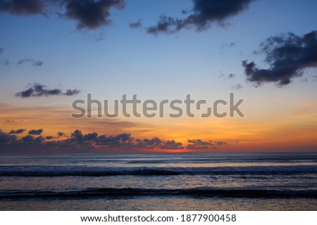 Sunset view on the beach of Kuta Bali, Indonesia, with gradations of yellow, orange and blue sky