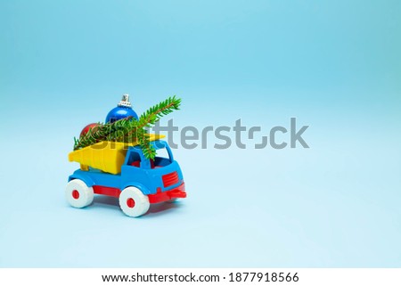 Children's toy truck filled with Christmas tree decorations. New year concept. Machines
and on a blue background