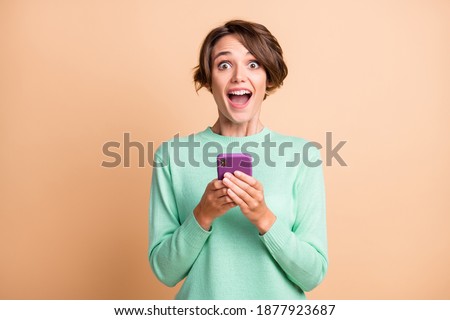 Photo of young attractive girl shocked amazed crazy news post use cellphone isolated over pastel color background