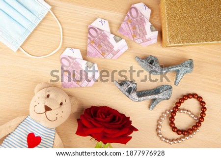 image of toy bear shoes flower bracelet mask box wooden desk background 