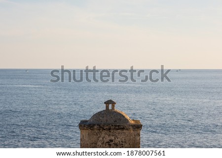The horizon beyond which we find Libya seen from the Apulian coast in southern Italy, we are in Leuca on the Ionian Sea, a concept of travel, the historic construction represents the staple. Royalty-Free Stock Photo #1878007561