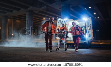 Team of EMS Paramedics React Quick to Bring Injured Patient to Healthcare Hospital and Get Him Out of Ambulance on a Stretcher. Blur Royalty-Free Stock Photo #1878018091