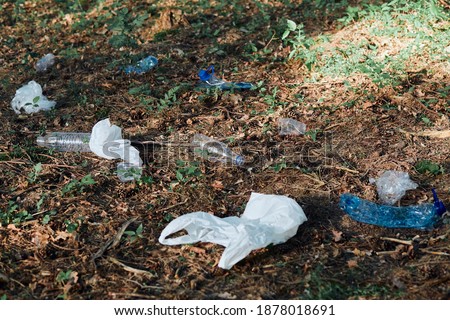 Plastic waste left in forest. Concept of plastic pollution and irresponsibility for environment. Environmental issue. Environmental damage. Real people, authentic situations Royalty-Free Stock Photo #1878018691