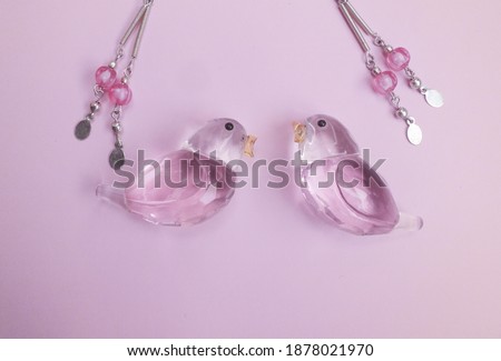 Attractive pink theme wallpaper of fashionable stuff with earing, glass bird and ornaments