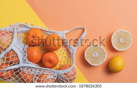 Fruits in cotton mesh bag on geometric background
