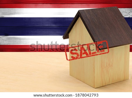 The concept sale of apartments, of real estate mortgages, citizenship and accommodation, as well as investment in a future home. Thailand flag on wooden background.