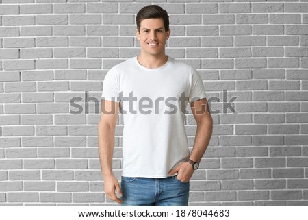 Man in stylish t-shirt on brick background