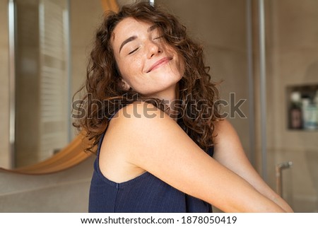 Happy young woman feeling relaxed with eyes closed. Smiling woman stretching with hands forward feeling fresh on a bright morning. Beautiful girl stretch herself in the morning. Royalty-Free Stock Photo #1878050419