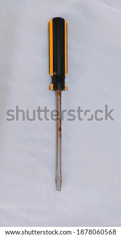 A rusted metal screw driver with a plastic handle