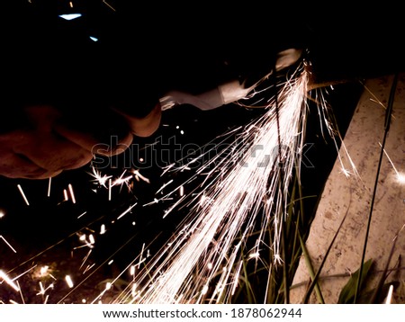 Light blue and yellow sparks on black background and human hands, aceh indonesia