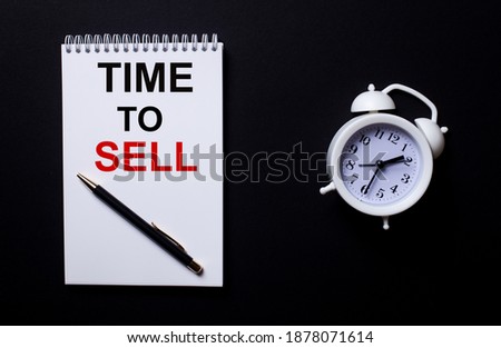 TIME TO SELL is written in a white notepad near a white alarm clock on a black background.