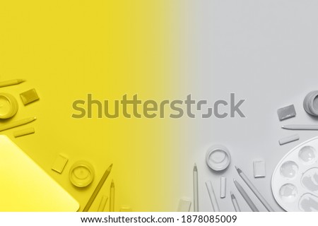 Artist workplace with lluminating Yellow and Ultimate Gray painter tools. Creative design demonstrating colors of the year 2021 with copy space