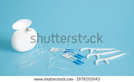 Home dental care kit. Different tools for dental care on blue background. Floss picks floss interdental brush. Top view Royalty-Free Stock Photo #1878105043