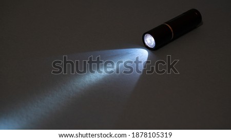 Flashlight and a beam of light in the dark. Flashlight ray in the darkness. Torchlight in the darkness Royalty-Free Stock Photo #1878105319